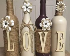 three wine bottles decorated with twine and flowers