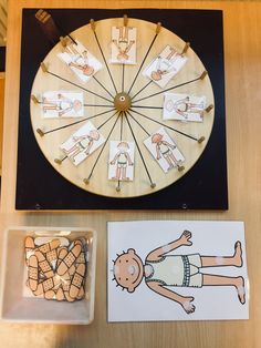 a wooden table topped with lots of cards next to a wheel of fortune game on top of a wall