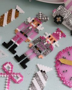 some pink and silver sequins are laying on a table with other sequins