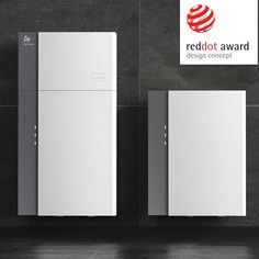 two white refrigerators sitting next to each other on a black tiled wall with the red dot award logo above them