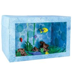 an aquarium with fish, rocks and plants in the water on a white background that is cut out from cardboard