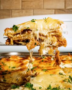 a piece of lasagna being lifted from an oven