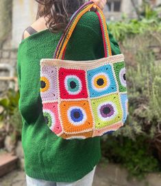 a woman carrying a colorful crocheted bag