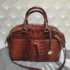 Designed In Massachusetts, Brahmin's Leslie Satchel Comes In A Beautiful Pecan Color Embossed Leather. The Bag Has A Soft Dome Silhouette And Wide Zip Top Opening. It Is Similar To It’s Cousin Marissa, But Features A Beautifully Pleated Slip Front Pocket. There Is One Inside Zipper Pocket, Two Inside Organizer Pockets, Key Finder And Two Pen Holders. An Adjustable And Detachable Crossbody 42 Inch Strap Completes The Look. Almost New Condition. Minimal Wear On Feet. Includes A Brahmin Dustbag. L1 Key Finder, Brahmin Bags, Pen Holders, Zip Top, Embossed Leather, Massachusetts, Front Pocket, Zipper Pocket, Satchel