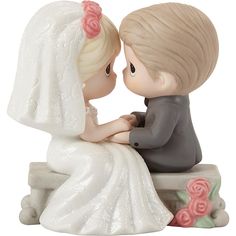 a bride and groom figurine sitting next to each other