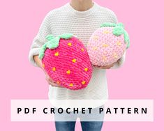 a woman holding two crocheted strawberries in her hands with the text, free pattern