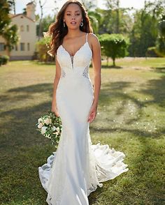 a woman in a wedding dress standing on the grass