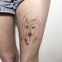 a woman's thigh with a tattoo of a wolf on the lower part of her leg