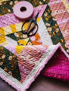 a pair of scissors sitting on top of a quilt