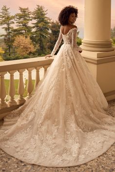 a woman in a wedding dress standing on a balcony