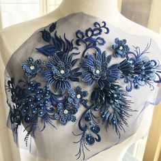 a mannequin with blue flowers and pearls on it