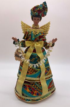 a figurine wearing a colorful dress and headdress with gold trimmings