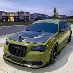 a green car parked on the side of a road