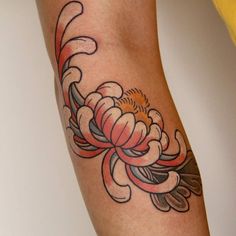 a woman's arm with a flower tattoo on it