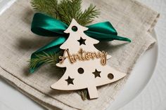 a wooden christmas ornament sitting on top of a plate next to a napkin