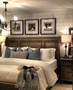 a large bed sitting in a bedroom next to two lamps and pictures on the wall