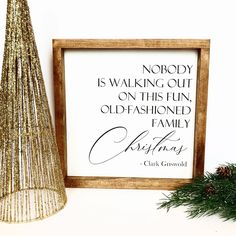 a christmas tree next to a framed sign with the words nobody is walking out on this fun, old fashioned family christmas