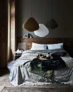 a bed with two hanging lamps above it