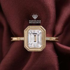 a diamond ring on top of a maroon satin material with the words marvelous engagement written above it