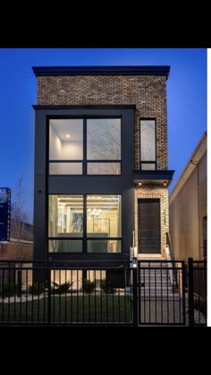 a modern house with large windows on the front and side of it, in an urban area