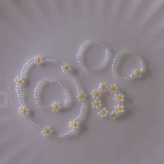 three beads are arranged in the shape of an o - ring and two small flowers