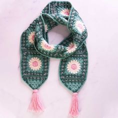 a green scarf with pink and white flowers on it