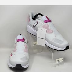 a pair of white and pink sneakers with tags on the soles are sitting next to each other