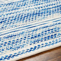 a blue and white area rug on a wooden floor with a wood floor in the background