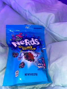 a bag of nerds candy sitting on top of a bed