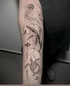 a man with a tattoo on his arm that has various symbols and birds in it