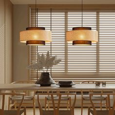 a dining room table with chairs and two lamps hanging over it, in front of a window