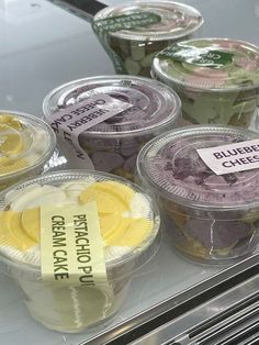 plastic cups with different types of ice cream on display in a store or restaurant case