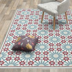 a chair sitting on top of a wooden floor next to a blue and red rug