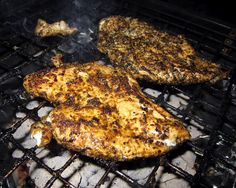 two pieces of chicken cooking on an outdoor grill