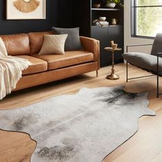 a living room with two couches and a rug on the floor in front of a window