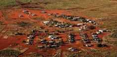 an aerial view of a small town in the middle of nowhere, surrounded by dirt and grass