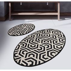 two black and white rugs sitting on top of a floor next to a sink