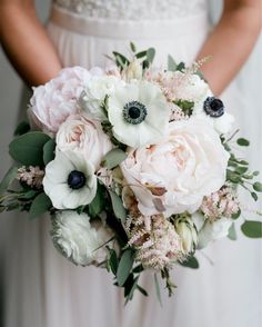 a bridal holding a bouquet of white and pink flowers