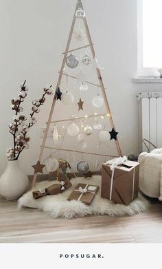 a white christmas tree with ornaments and presents on the floor in front of a window