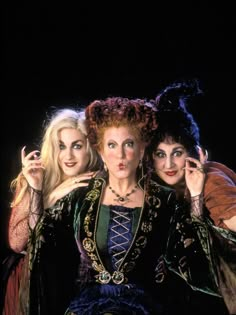 three women dressed in costumes posing for the camera