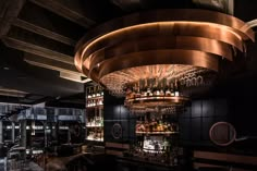 a dimly lit bar with lots of bottles and glasses hanging from it's ceiling