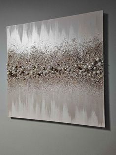 an abstract painting on the wall with silver and white paint, it looks like something out of