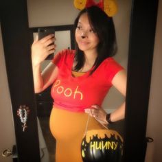 a pregnant woman taking a selfie in front of a mirror with her cell phone