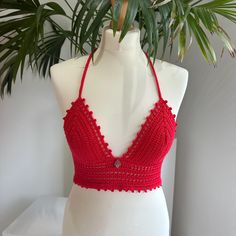 Handmade red Crochet Bralette Crop Top with adjustable tie back and metal hamsa charm embellishment. This top is made in a high quality beautiful bright red yarn and features a fully adjustable halterneck tie, and a fully adjustable tie up back. It also features a metal hamsa charm in the front center.  Due to its customisable nature, this top would fit someone between the sizes of UK 6/8 to UK14. Approximate cup size A - C. Displayed on a UK size 8/10 mannequin.  PLEASE NOTE - since this is a h Red Fitted Bohemian Halter Top, Fitted Bohemian Red Halter Top, Red Triangle Halter Top For Party, Red Triangle Top For Festival, Top Rojo, Red Crochet, Hamsa Charm, Crochet Bralette, Red Yarn