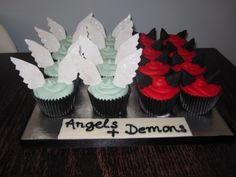 cupcakes with red and black frosting are arranged on a tray that says angel's demons