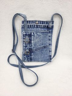 a small blue jean purse with an adjustable strap and two pockets on the front side