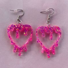 these lightweight drippy heart earrings are made with a vibrant pink glitter that has reflects of orange, blue and green - other colours available Pink Heart Resin Earrings, Pink Resin Heart Earrings, Goofy Earrings, Drippy Heart, Glitter Jewelry, Resin Crafts Tutorial, Diy Earrings Polymer Clay, Pink Jewelry, Resin Earrings