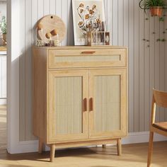 a wooden cabinet with wicker doors and drawers in a room next to a chair