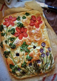 a pizza with tomatoes, broccoli and other toppings on top of it