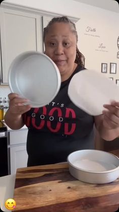 a woman is holding two plates in her hands while standing next to a bowl on the counter